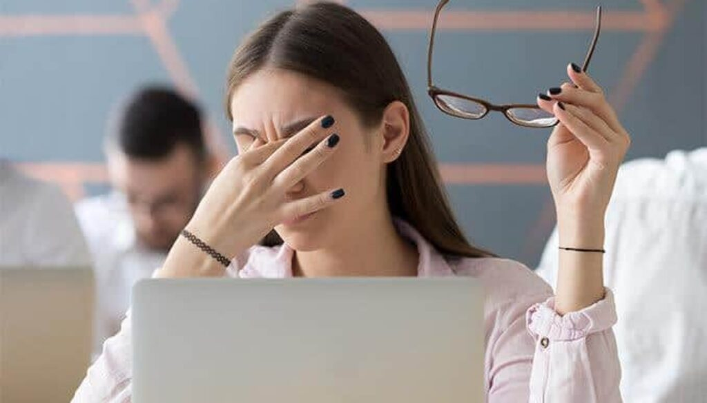 This image represents digital eye strain and screen fatigue, showing the discomfort people may experience after prolonged computer or screen use.