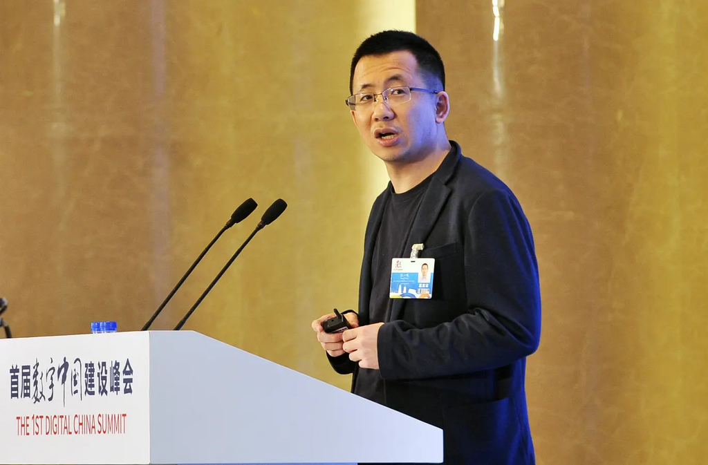 A professional speaking at a technology conference, presenting from a podium at the 1st Digital China Summit. The image highlights digital transformation, technological innovation, public speaking, and advancements in China’s digital economy.