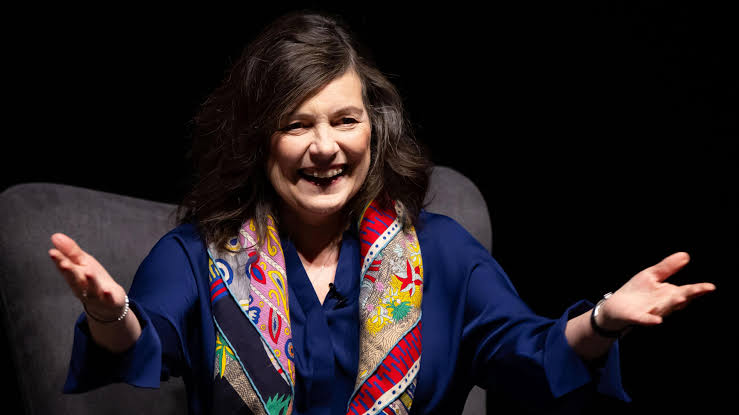 This image represents female leadership, public speaking, and business or technology discussions. It shows a woman speaking confidently on stage, making it suitable for articles about women in leadership, entrepreneurship, innovation, technology, workplace culture, or professional events.