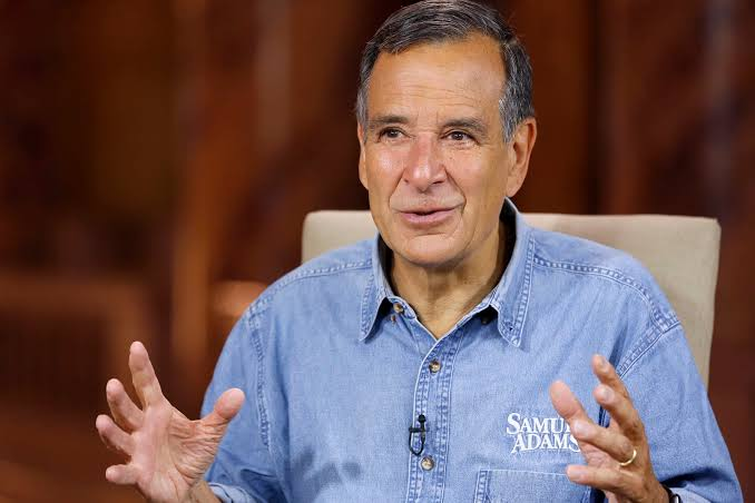 To promote the Samuel Adams brand by featuring its representative speaking with expressive hand gestures, highlighting the company’s brewing expertise, brand identity, and commitment to quality and tradition.